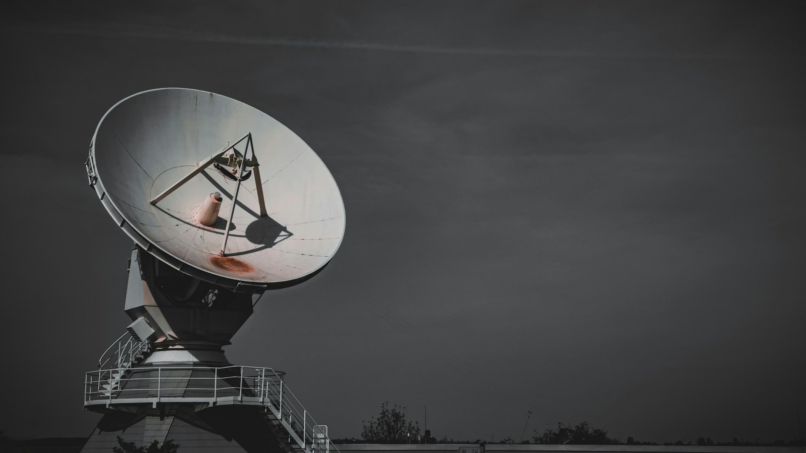 A large dish antenna against an overcast sky