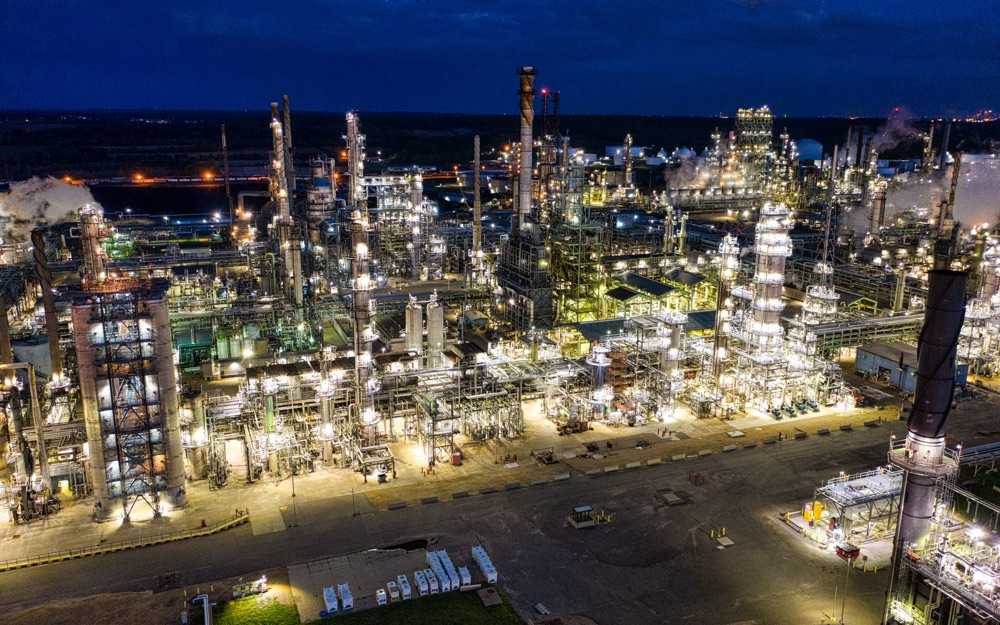 A refinery lit up at night, seen from the air